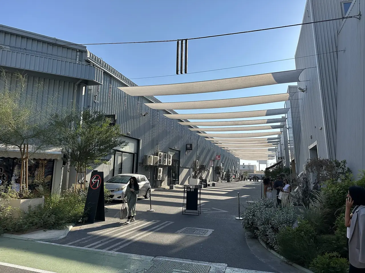 The Best Day in Dubai: A One-Day Itinerary With Every Dirham Counted 13 A lane between grey warehouses in Alserkal Avenue, Al Quoz, Dubai, shaded by fabric sails